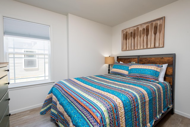 bedroom featuring baseboards and wood finished floors