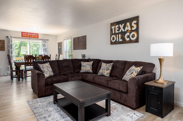 living area featuring light wood-style floors and baseboards