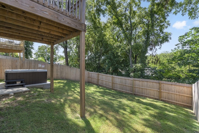 view of yard featuring a hot tub and a fenced backyard