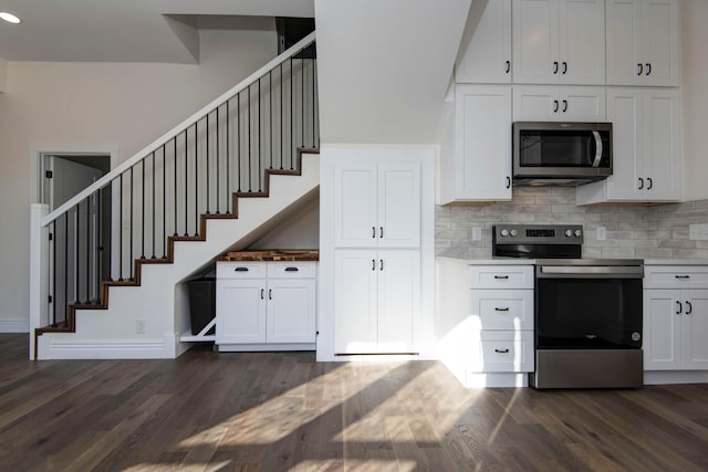 kitchen featuring stainless steel appliances, white cabinetry, dark wood finished floors, and backsplash