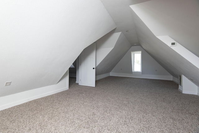 additional living space with lofted ceiling, carpet, visible vents, and baseboards