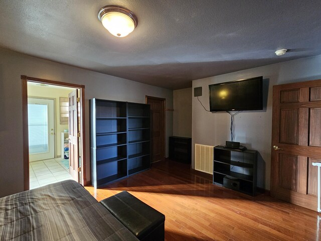 unfurnished bedroom featuring a textured ceiling, wood finished floors, and visible vents