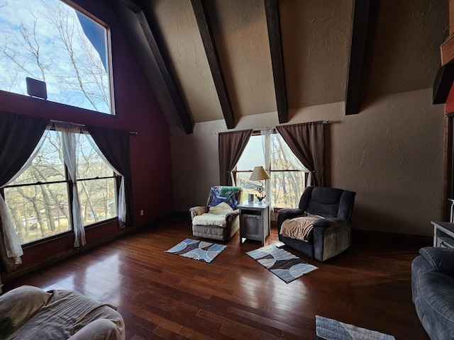 sitting room featuring a textured wall, wood-type flooring, beamed ceiling, and high vaulted ceiling