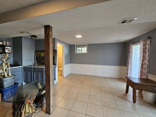 dining space with a textured ceiling, light tile patterned flooring, and visible vents