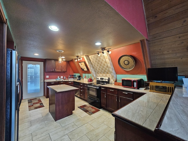 kitchen featuring electric stove, a center island, freestanding refrigerator, light countertops, and a textured ceiling