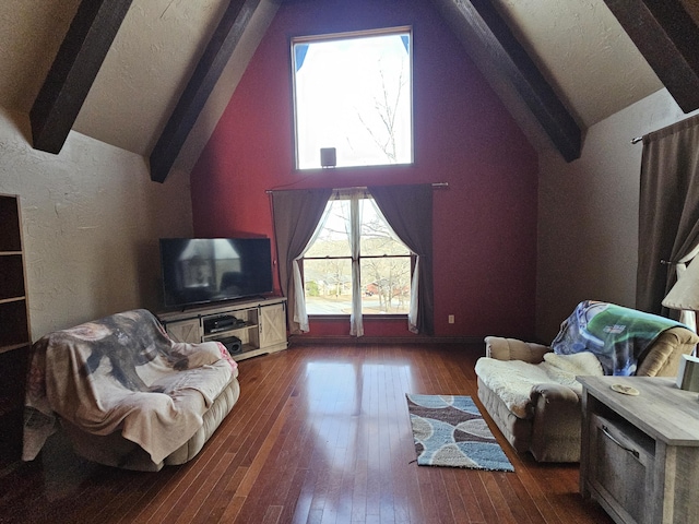 living area featuring lofted ceiling with beams, hardwood / wood-style flooring, and a textured ceiling