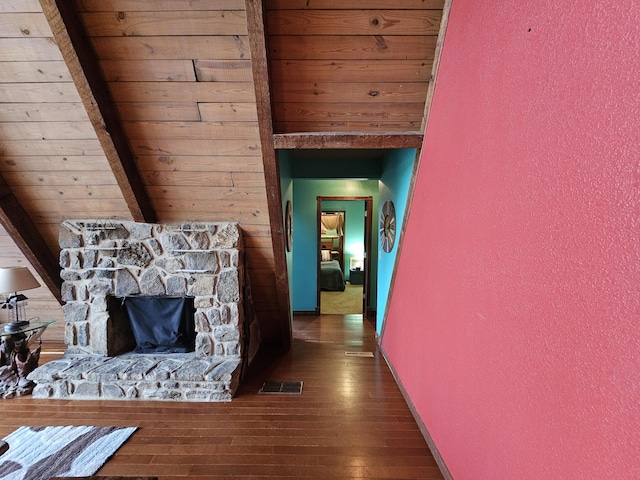 hallway with hardwood / wood-style floors, beamed ceiling, and visible vents