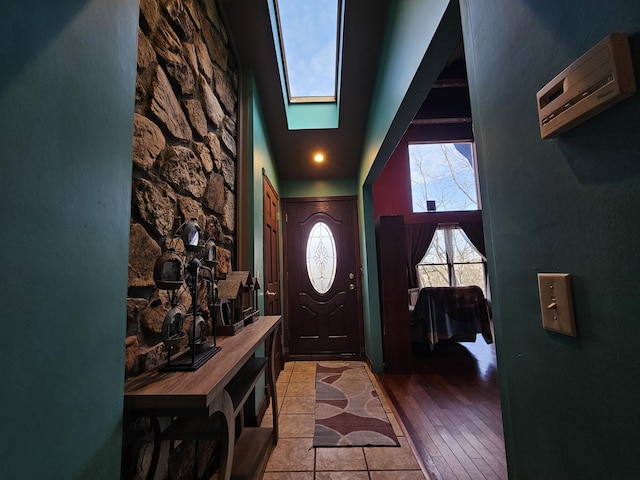 entryway with a skylight and a towering ceiling