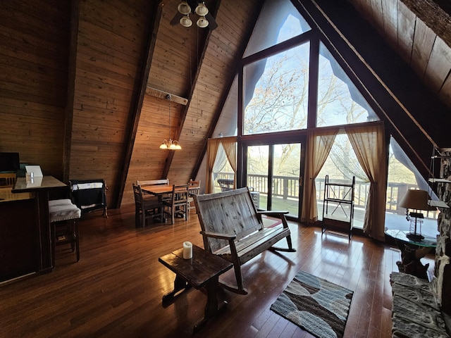 living area with wood-type flooring, a healthy amount of sunlight, and wooden ceiling