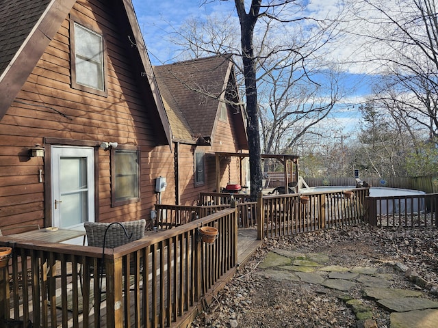 wooden deck with a fenced backyard and a fenced in pool