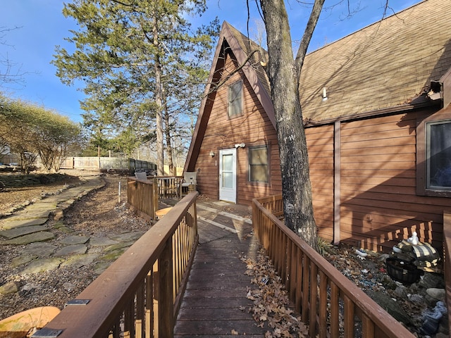 exterior space featuring a shingled roof and fence