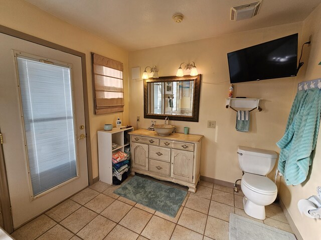 bathroom with toilet, vanity, baseboards, visible vents, and tile patterned floors