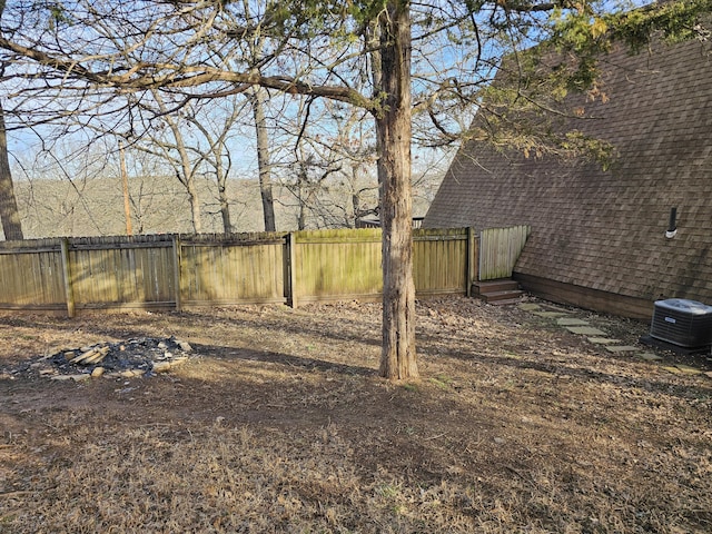 view of yard with central AC unit and fence