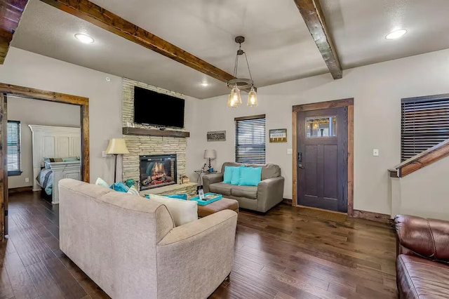 living room with dark wood-type flooring, beamed ceiling, baseboards, and a barn door