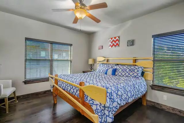 bedroom with a ceiling fan, multiple windows, baseboards, and wood finished floors