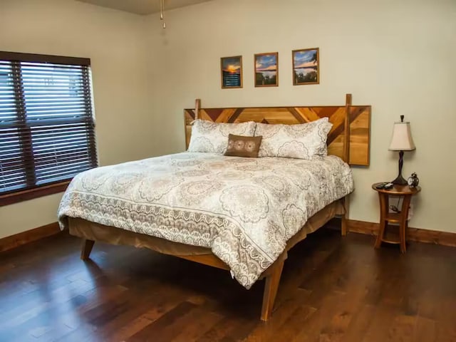 bedroom featuring wood finished floors and baseboards