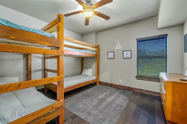 bedroom with ceiling fan, dark wood-type flooring, and baseboards