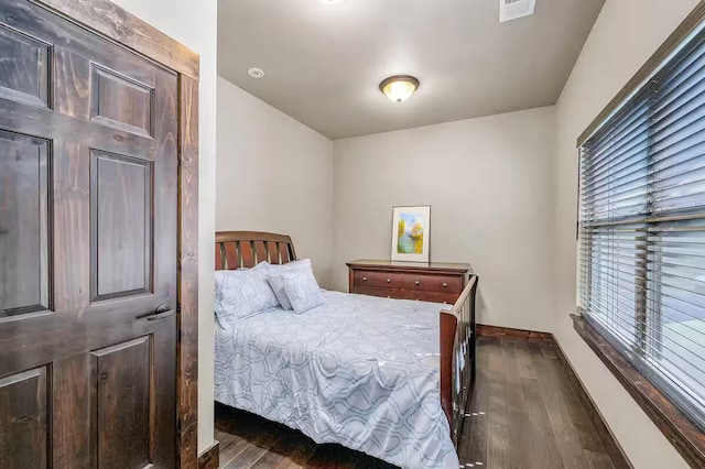 bedroom featuring visible vents, baseboards, and dark wood-style flooring