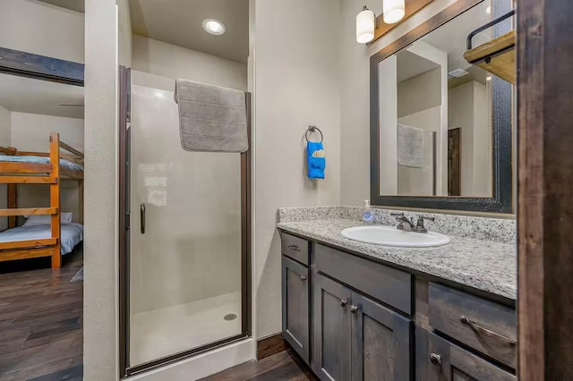 bathroom featuring a stall shower, vanity, and wood finished floors