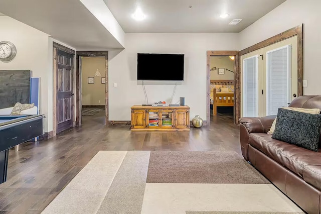 living room featuring visible vents, baseboards, and wood finished floors