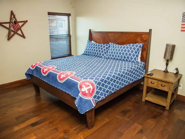 bedroom with baseboards and wood finished floors