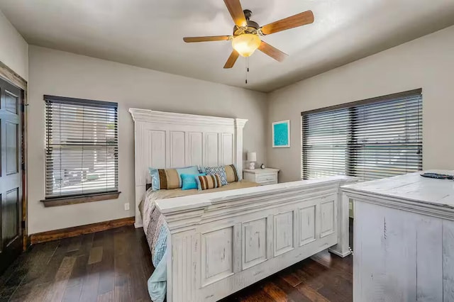 bedroom featuring a ceiling fan, multiple windows, dark wood finished floors, and baseboards