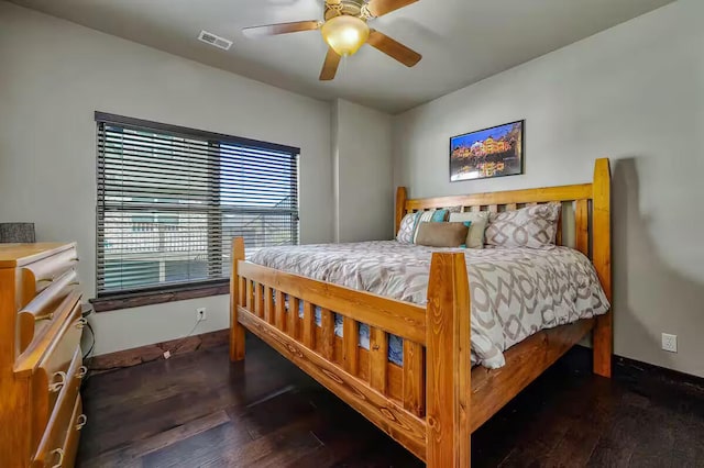 bedroom featuring ceiling fan, wood finished floors, visible vents, and baseboards