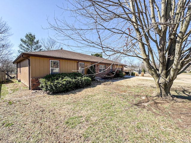 view of home's exterior with a lawn and brick siding