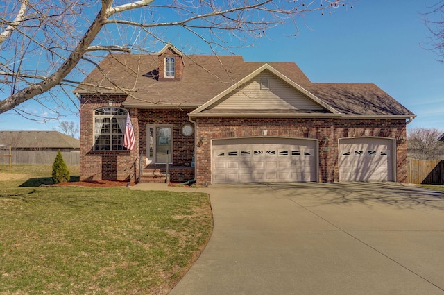 view of front of home featuring brick siding, an attached garage, fence, driveway, and a front lawn