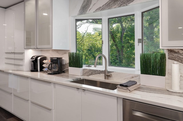 kitchen featuring tasteful backsplash, glass insert cabinets, white cabinets, and a sink