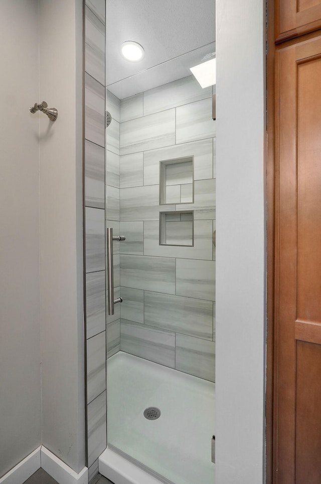 bathroom featuring a stall shower and baseboards