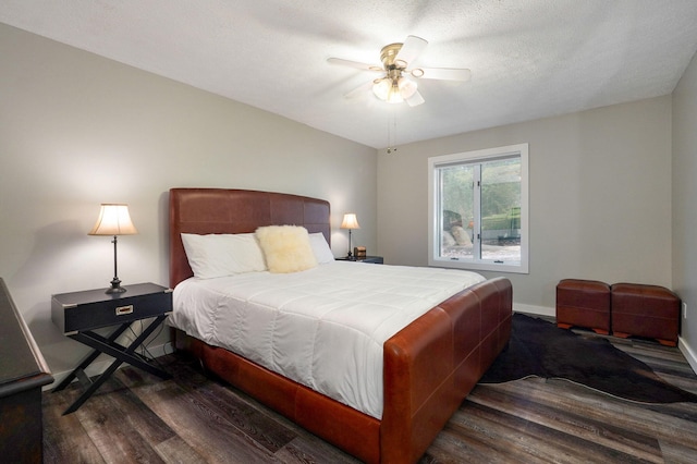 bedroom with a ceiling fan, a textured ceiling, baseboards, and wood finished floors