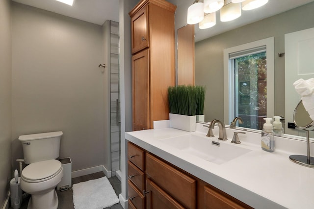 bathroom featuring vanity, toilet, and baseboards