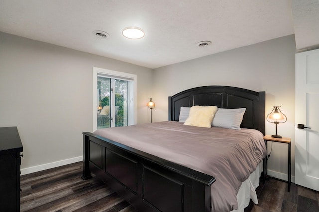 bedroom featuring dark wood-style flooring, visible vents, and baseboards