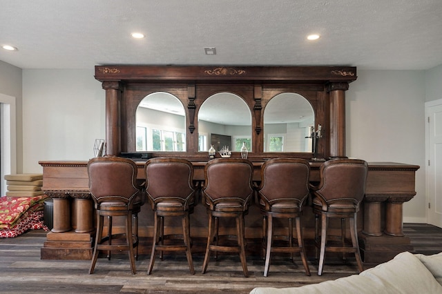 bar with recessed lighting, wood finished floors, and wet bar