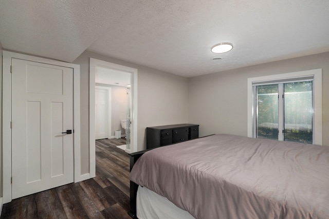 bedroom featuring dark wood-style floors, connected bathroom, and a textured ceiling