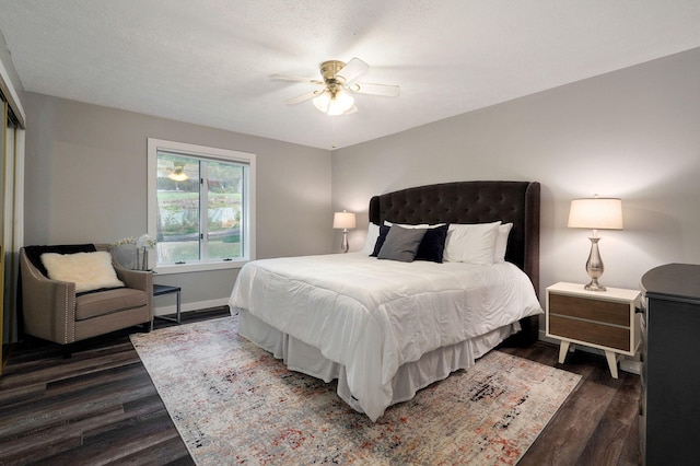 bedroom with ceiling fan, dark wood-style flooring, a textured ceiling, and baseboards