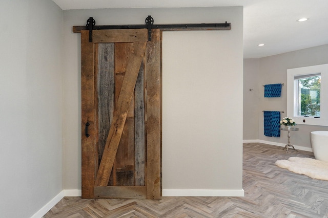 bathroom featuring a freestanding tub, baseboards, and recessed lighting