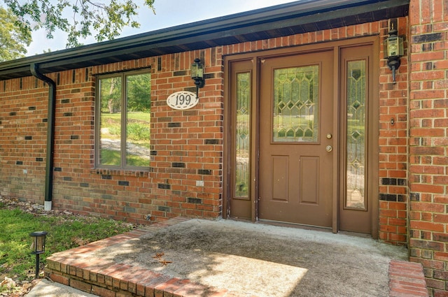 doorway to property with brick siding