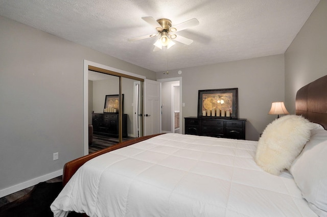 bedroom with a textured ceiling, a closet, a ceiling fan, and baseboards