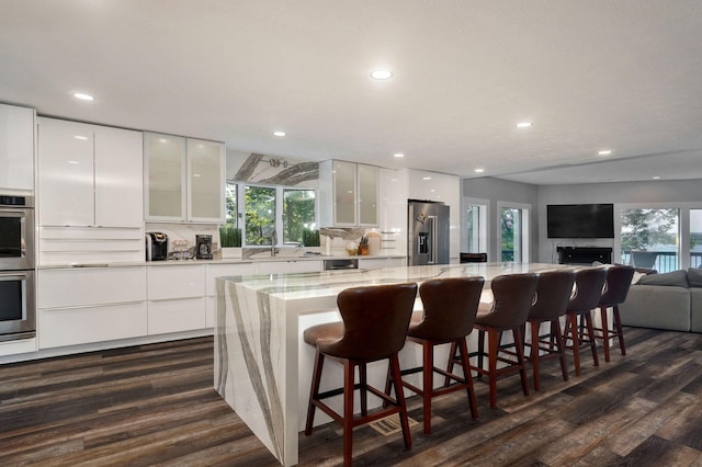 kitchen featuring white cabinets, decorative backsplash, a spacious island, modern cabinets, and stainless steel appliances