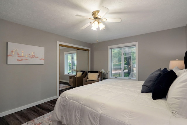 bedroom featuring a closet, multiple windows, wood finished floors, and baseboards