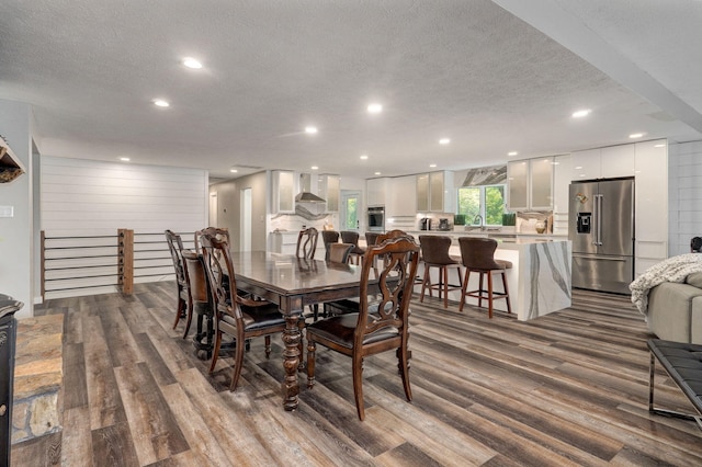 dining space featuring a textured ceiling, dark wood-type flooring, and recessed lighting