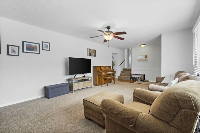 living room with stairway, carpet, a ceiling fan, and baseboards