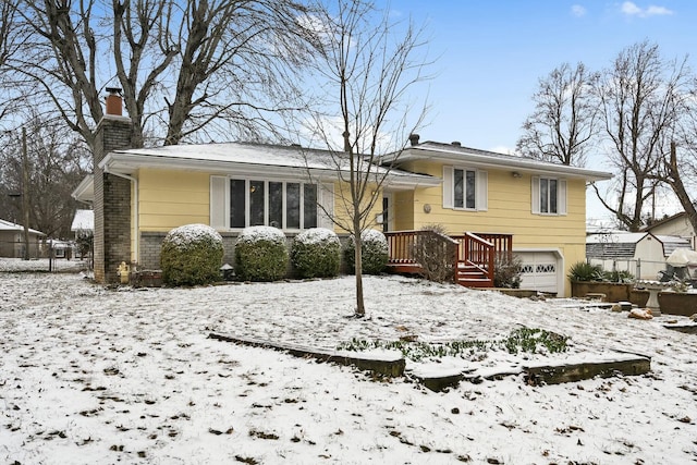 view of front of house featuring a garage, brick siding, and a chimney