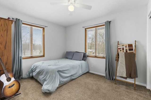 bedroom featuring multiple windows, carpet flooring, a ceiling fan, and baseboards