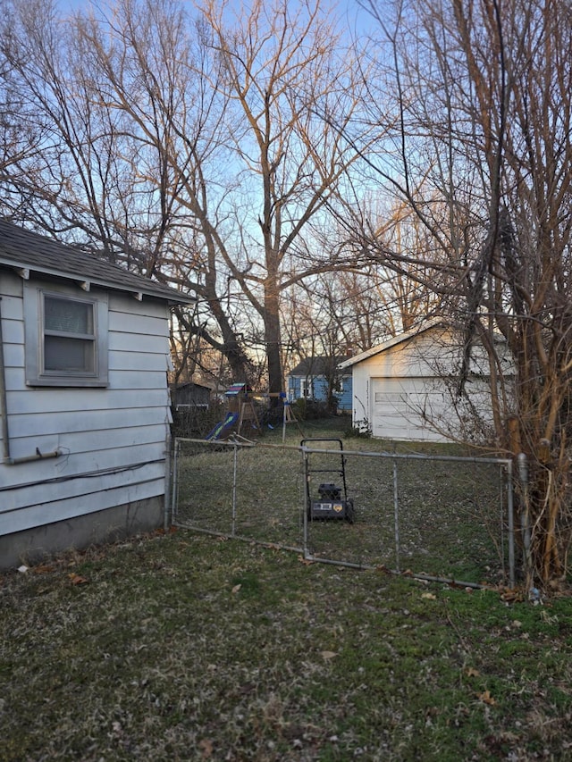 view of yard featuring a gate, fence, and an outbuilding