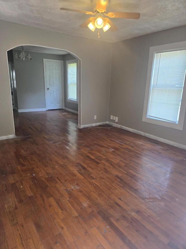 2140 N Roosevelt Ave, Springfield, MO 65803 - unfurnished room featuring arched walkways, dark wood-style floors, a ceiling fan, a textured ceiling, and a chandelier