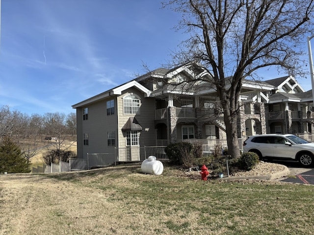 view of front of house featuring a front lawn and a balcony