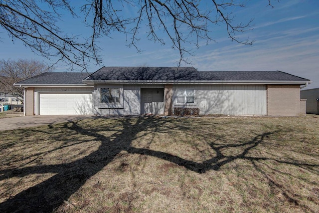 view of front of property with an attached garage, driveway, brick siding, and a front yard